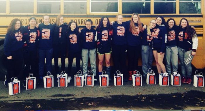 Team photo in front of school bus